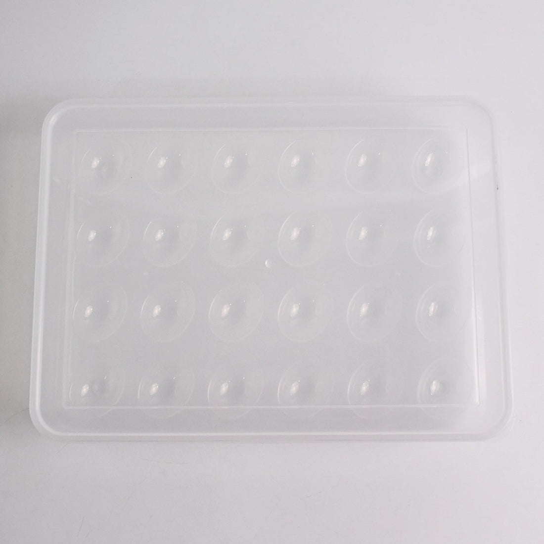 Clear plastic egg container next to traditional egg carton for size comparison