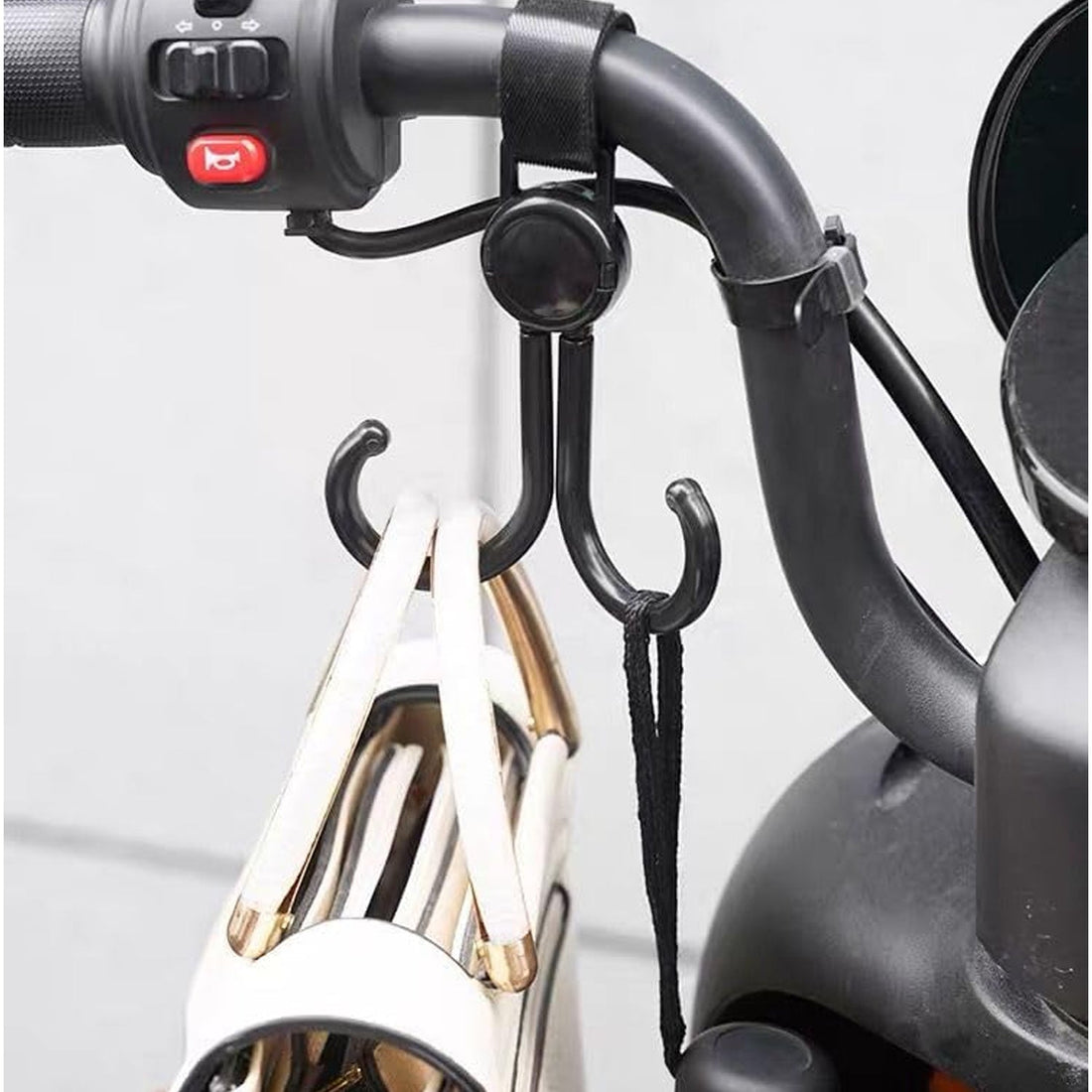 Multi-purpose stroller hook holding shopping bags and a purse on a pram.