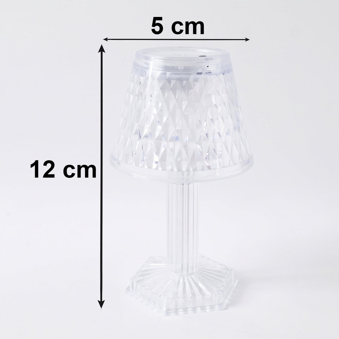 Small crystal table lamp creating a warm, ambient glow in a dark room.